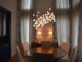 This beautiful, elegant dining room control, lighting, and window treatments with Lutron and invisible speaker