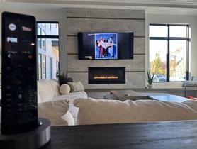 A Family Room highlighting a custom soundbar to match the TV, and surround provided with invisible speakers.